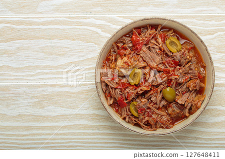 Ropa vieja with white rice, tomato sauce and green olives on a plate top view, traditional dish of Cuba Ropa vieja with white rice, tomato sauce and green olives on a plate top view, traditional dish of Cuba 127648411