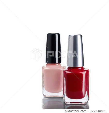 Two nail polish bottles in contrasting colors set against a simple background 127648498