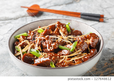 Stir fried beef ginger with lightly sweet sauce, green onion and sesame closeup in the bowl. Horizontal Stir fried beef ginger with lightly sweet sauce, green onion and sesame closeup in the bowl. Horizontal 127648612