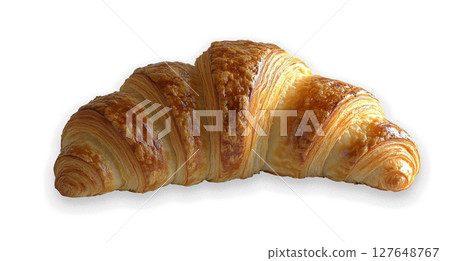 Freshly baked buttery croissant resting on a smooth surface in morning light 127648767