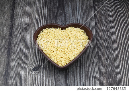 Raw Organic Stelline Pasta in a Bowl, top view. Flat lay, overhead, from above. Macaroni stars. Star shaped noodles. 127648885
