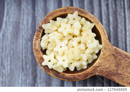 Raw Organic Stelline Pasta in a Bowl, top view. Flat lay, overhead, from above. Macaroni stars. Star shaped noodles. Raw Organic Stelline Pasta in a Bowl, top view. Flat lay, overhead, from above. Macaroni stars. Star shaped noodles. 127648889