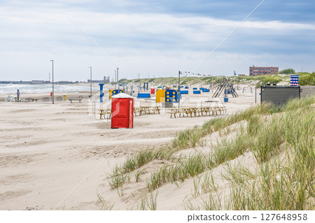 Wide sandy Ventspils Beach with colorful changing cabins and grassy Baltic dunes 127648958