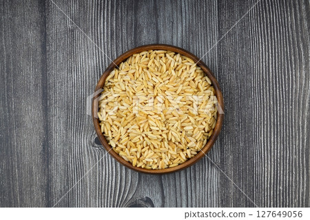 Raw fresh and healthy dry organic barley noodle on wooden spoon 127649056