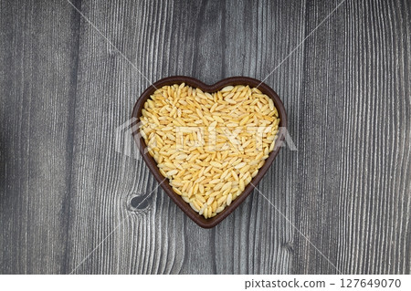 Raw fresh and healthy dry organic barley noodle on wooden spoon 127649070
