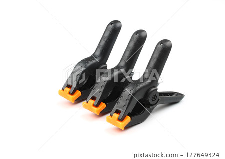 black plastic spring clamp isolated over white background black plastic spring clamp isolated over white background 127649324