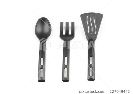 Black plastic kitchen spatula and spoon isolated on white background 127649442