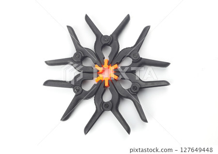 black plastic spring clamp isolated over white background black plastic spring clamp isolated over white background 127649448