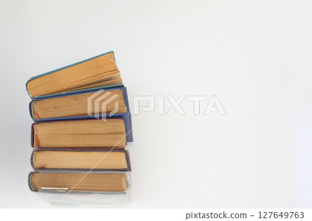 Stack of books in colour covers with white sheets isolated on a white background 127649763