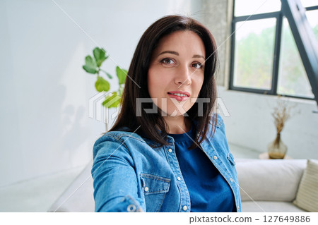 Selfie portrait happy beautiful woman in home interior 127649886
