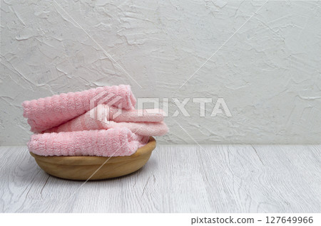 Pink fluffy towels folded neatly on a light surface, ideal for mockups with room for your design or message. 127649966