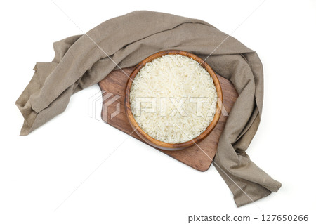 Raw white rice on wooden background. Long uncooked rice in wooden plate. Natural organic food. Traditional Asian cereal culture. Raw white rice on wooden background. Long uncooked rice in wooden plate. Natural organic food. Traditional Asian cereal culture. 127650266