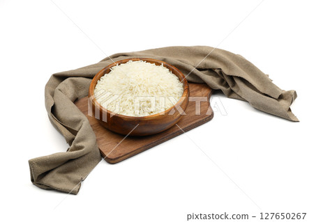 Raw white rice on wooden background. Long uncooked rice in wooden plate. Natural organic food. Traditional Asian cereal culture. Raw white rice on wooden background. Long uncooked rice in wooden plate. Natural organic food. Traditional Asian cereal culture. 127650267