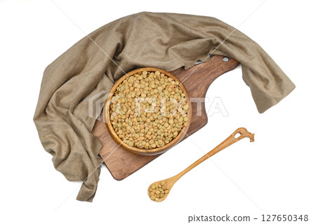 Green lentils in wooden bowl on isolated white background. Top view, copy space. Flat lay. 127650348