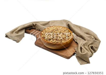 Green lentils in wooden bowl on isolated white background. Top view, copy space. Flat lay. Green lentils in wooden bowl on isolated white background. Top view, copy space. Flat lay. 127650351