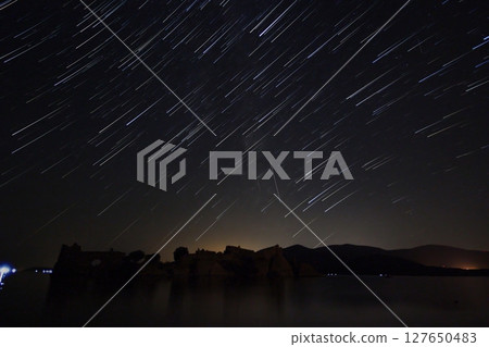 A view of the stars of the Milky Way with a mountain top in the foreground.Perseid Meteor Shower observation 127650483