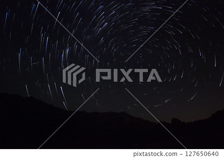A view of the stars of the Milky Way with a mountain top in the foreground.Perseid Meteor Shower observation 127650640