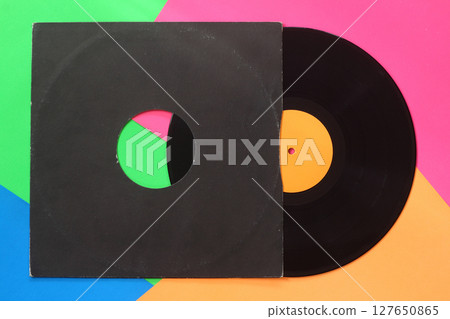 Aged black paper cover and blue vinyl LP record isolated on colorful background Aged black paper cover and blue vinyl LP record isolated on colorful background 127650865