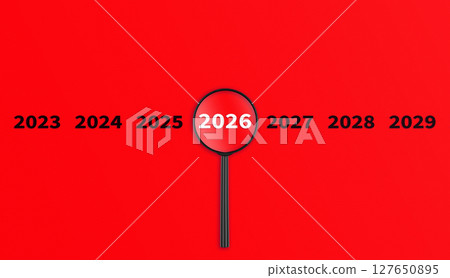 Lens, magnifying glass focusing on the year 2026 on a red background. Financial or stock market strategies and past and future events. 127650895