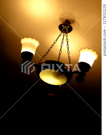 old retro chandelier on the ceiling yellow warm old retro chandelier on the ceiling yellow warm 127652229