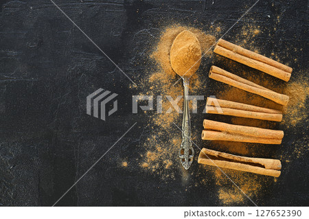 Cinnamon sticks and spoon on black background, top view Cinnamon sticks and spoon on black background, top view 127652390