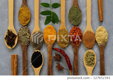 Different kind of spices on a wood background. Big set of Indian spices on wooden table. Different kind of spices on a wood background. Big set of Indian spices on wooden table. 127652391