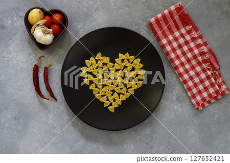 Italian Food background on stone table Top view. With heart shaped bowl 127652421