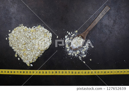 Oatmeal heart isolated on a dark background, with place for an inscription. Bunting heart symbol. Heart of cereals. Oatmeal heart isolated on a dark background, with place for an inscription. Bunting heart symbol. Heart of cereals. 127652639
