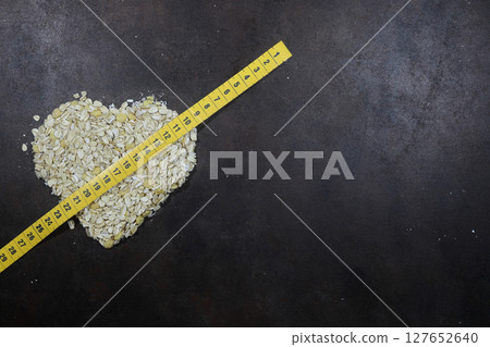 Oatmeal heart isolated on a dark background, with place for an inscription. Bunting heart symbol. Heart of cereals. Oatmeal heart isolated on a dark background, with place for an inscription. Bunting heart symbol. Heart of cereals. 127652640