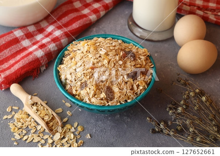 Oatmeal in a green bowl with a glass of milk on a gray background. A healthy, nutritious morning breakfast Oatmeal in a green bowl with a glass of milk on a gray background. A healthy, nutritious morning breakfast 127652661