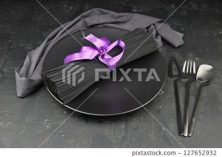 Raw black homemade spaghetti bunch isolated. Dry black noodles macaroni bundle. Close-up 127652932