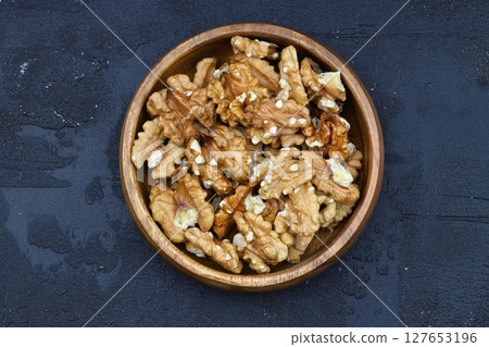 broken walnuts and nutcracker on black background 127653196