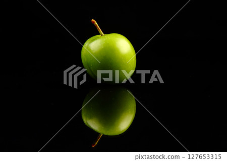 Green plums on black background 127653315