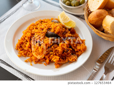 Delicious traditional Valencian seafood paella - savory rice dish with shrimps and clams 127653464