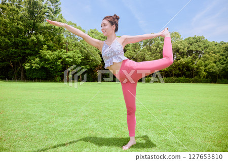 一位女士在天然草坪和藍天下,在度假氛圍中練習瑜伽和普拉提 一位女士在天然草坪和藍天下,在度假氛圍中練習瑜伽和普拉提 127653810