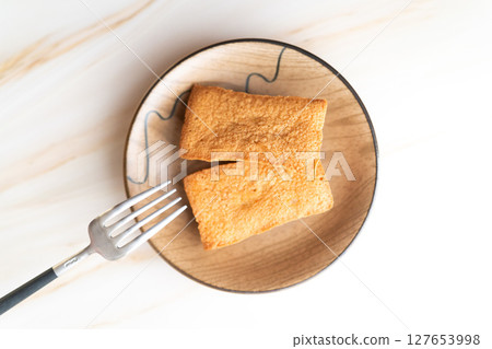 Financier sweets lined up on a wooden plate⑦ Financier sweets lined up on a wooden plate⑦ 127653998