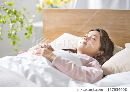 A young woman sleeping in bed A young woman sleeping in bed 127654008
