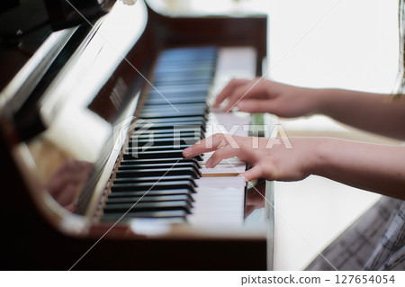 一位年輕的女士彈鋼琴 一位年輕的女士彈鋼琴 127654054