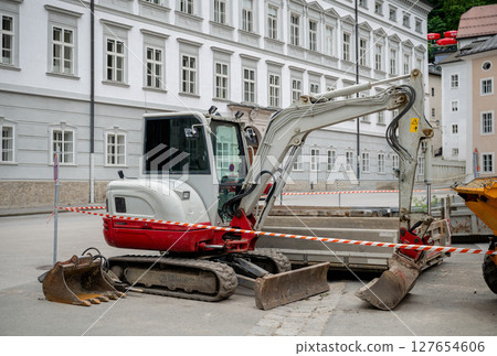 Excavator at construction site in city street, concept of roadwork and development 127654606