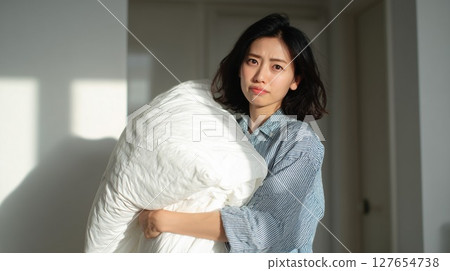 一位女士在存放被子時遇到了麻煩 一位女士在存放被子時遇到了麻煩 127654738