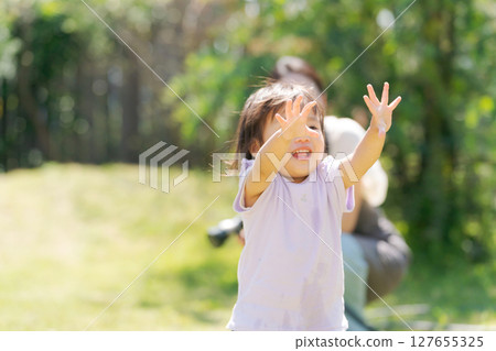 父母和孩子在綠色花園裡玩耍 127655325