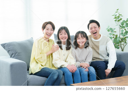Family relaxing on the sofa in the living room 127655660