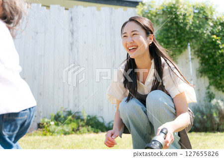 Mom watching over her child playing in the garden 127655826