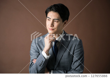 一位憂心忡忡的商人總統身穿棕色背景西裝，正在規劃戰略和戰術 127655866