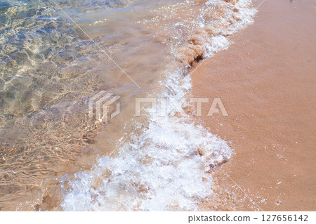 Sea Wave Washing Over Sandy Shoreline 127656142