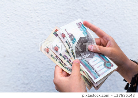 Close-up of female hands counting Egyptian pound banknotes 127656148
