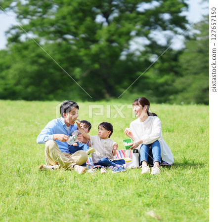 Family of four having a picnic in the park Family of four having a picnic in the park 127657150