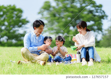 Family of four having a picnic in the park Family of four having a picnic in the park 127657157