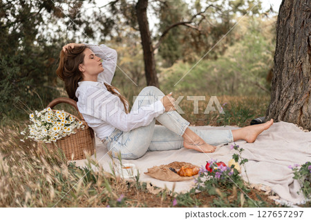 Woman picnic flowers park relaxes outdoors during daytime in nature. 127657297