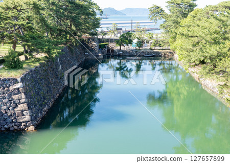 Stone walls and moat at Tamamo Park, historic site of Takamatsu Castle, Kagawa Prefecture 127657899